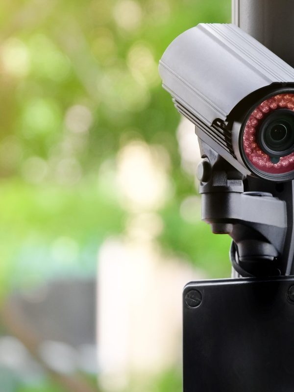 Modern public CCTV camera on a electric pole with blurred natural background. Intelligent reccording cameras for monitoring all day and night. Concept of surveillance and monitoring with copy space.